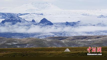 祁連山脈で初雪観測　雪山をバックに緑映える草原