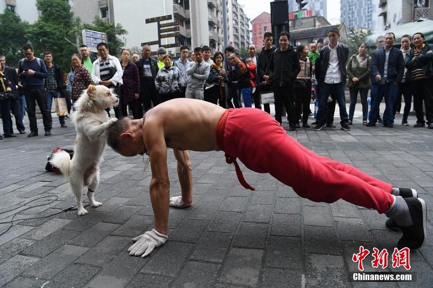 愛犬と街中でパフォーマンスを披露する75歳男性　重慶市

