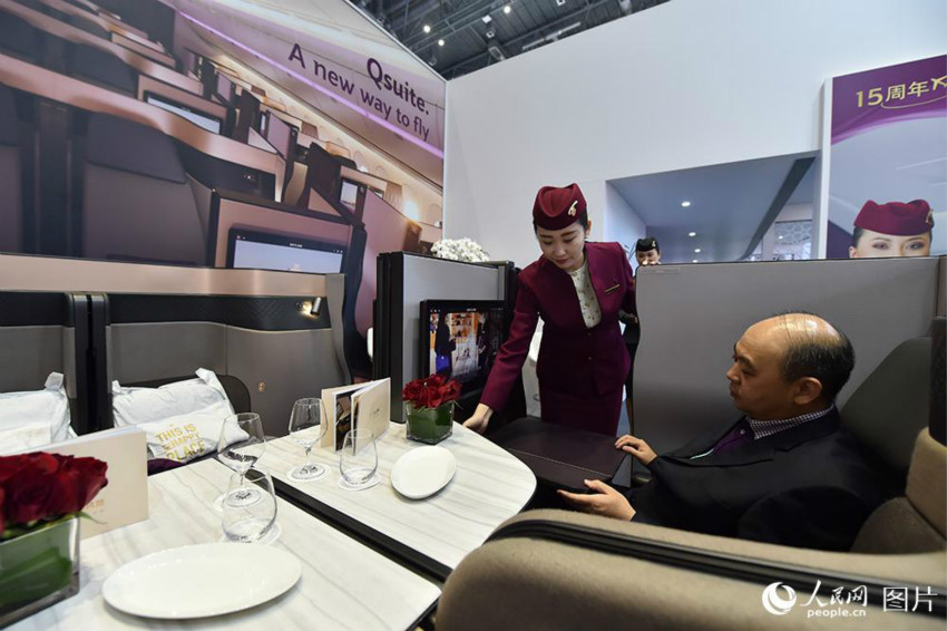 11月９日、輸入博覧会のカタール航空のブースで、来場者が機上のプライベート空間を体験する様子。