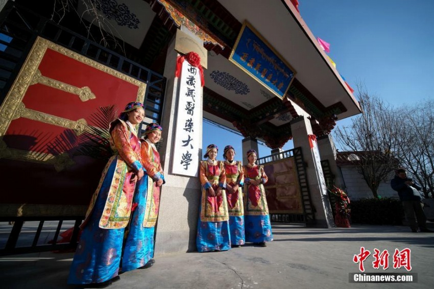 改名後の西藏藏医薬大学の校門で記念撮影をする学生たち（12月28日、撮影・何蓬磊）。