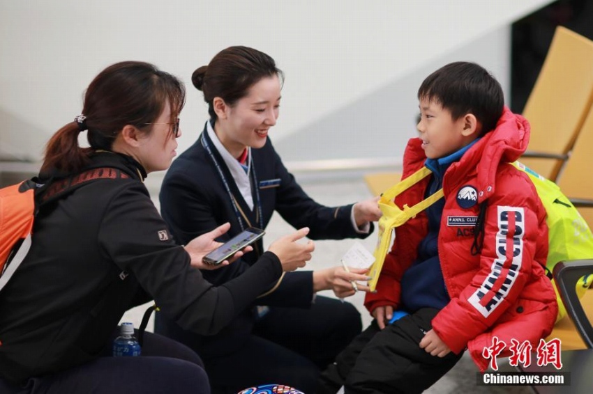 広州白雲空港で保護者と「子ども1人旅サービス」の手続きを行うグランドホステス（1月13日、撮影・劉芸）。