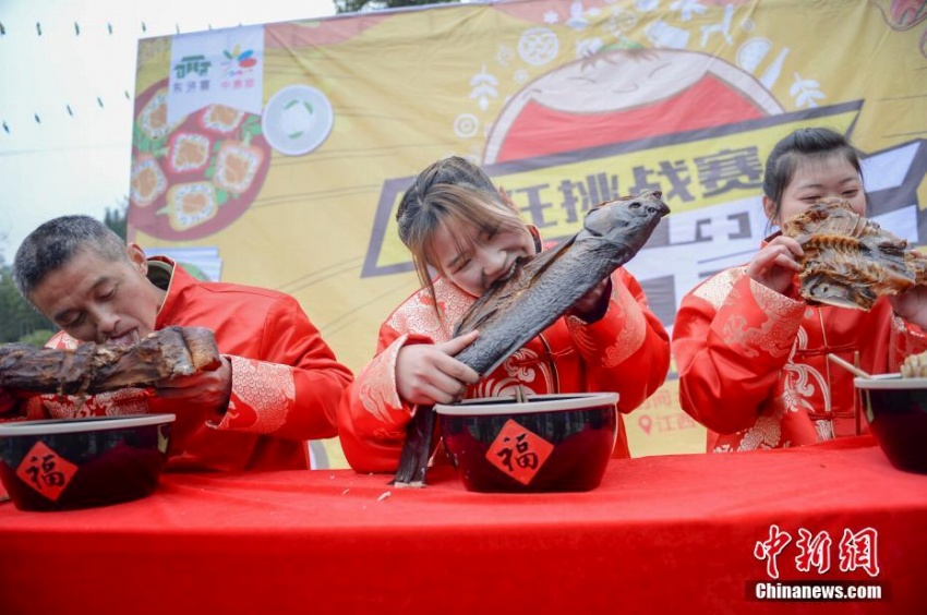 燻製食品大食い大会で王座目指し燻製魚にかぶりつく女性　中国