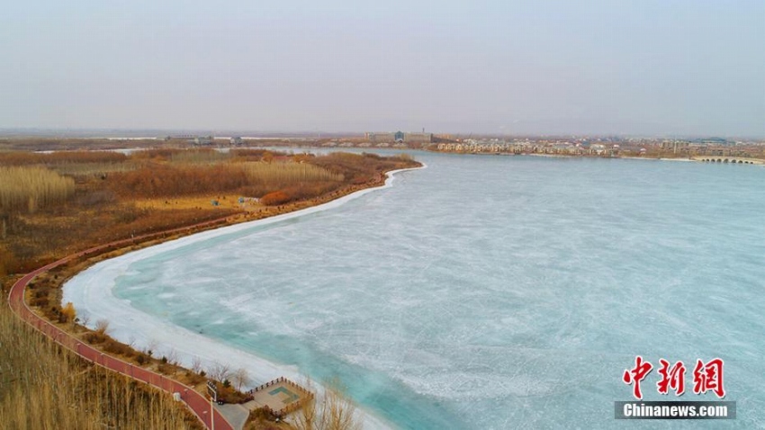 「寒の戻り」で美しい水色に凍った張掖国家湿地公園の湖　甘粛省