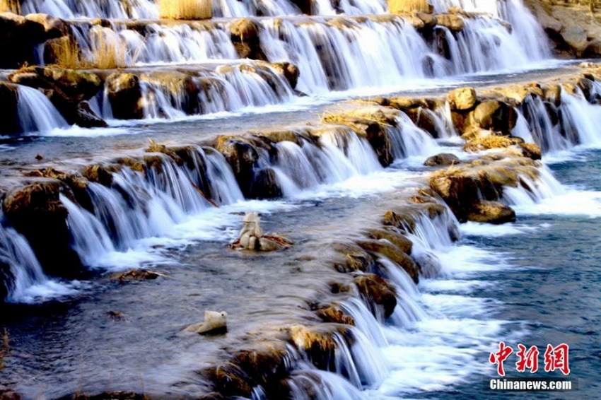 冬の間水が枯れていた張掖市濱河新区芦水湾景勝地に再び現れた滔々と流れる美しい滝(撮影・陳礼)。