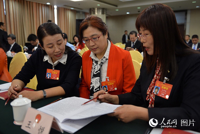 3月5日、遼寧代表団全体会議で、女性の代表が政府活動報告について意見を交換していた。（撮影：翁奇羽）