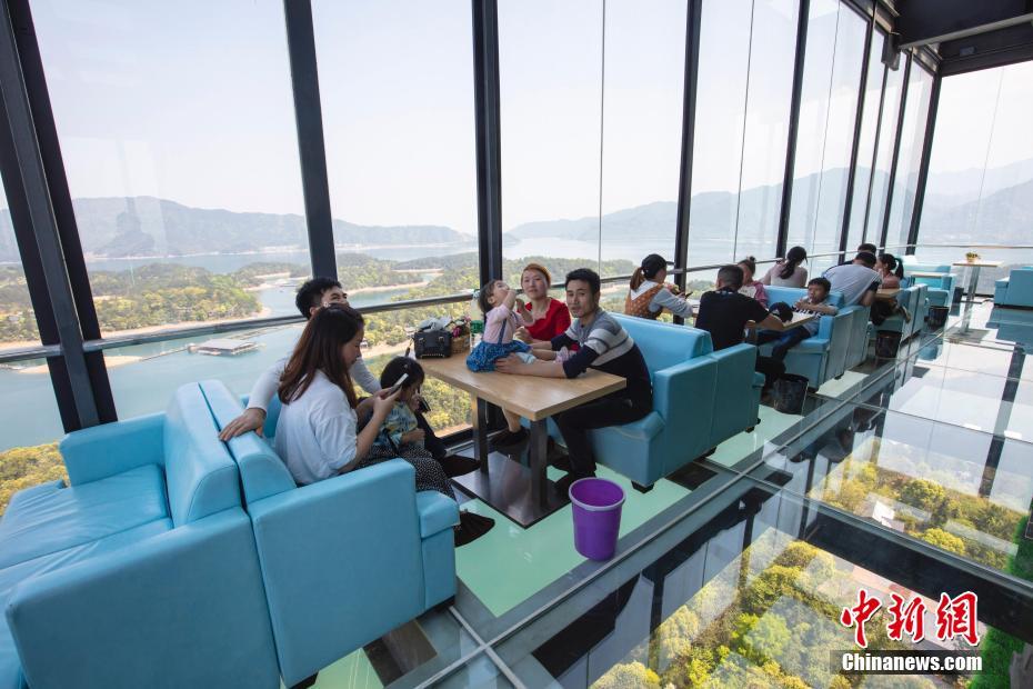 ガラス張りの観光タワーに設けられている「天空のカフェテリア」でくつろぐ観光客たち（撮影・張海岩）。