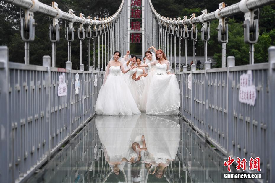 湖南省、女性労働者がウェディングドレスを着てガラスの吊り橋に集合