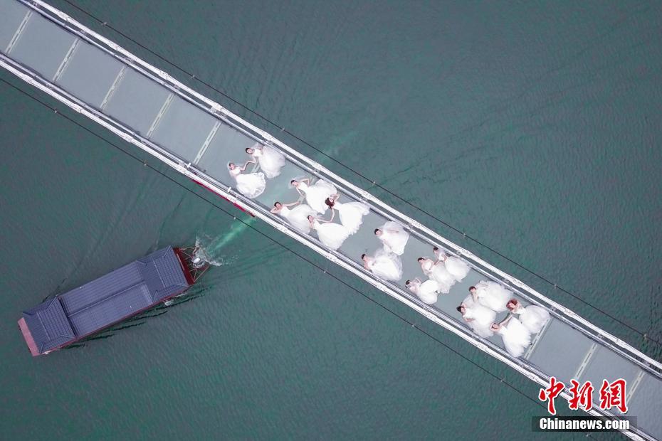湖南省、女性労働者がウェディングドレスを着てガラスの吊り橋に集合