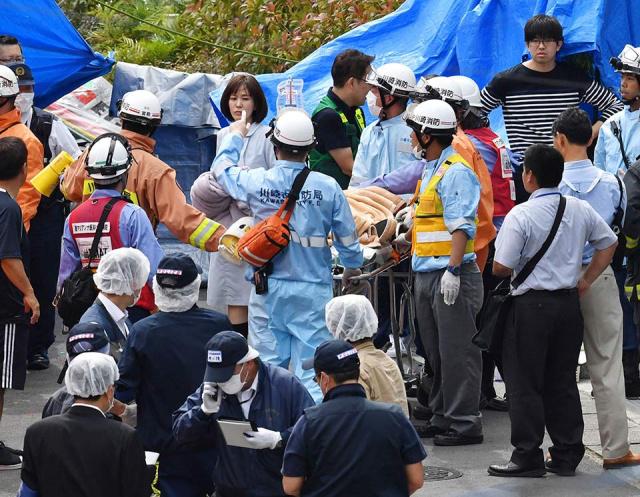5月28日、川崎市で男に刺された負傷者を搬送する救急隊員。 