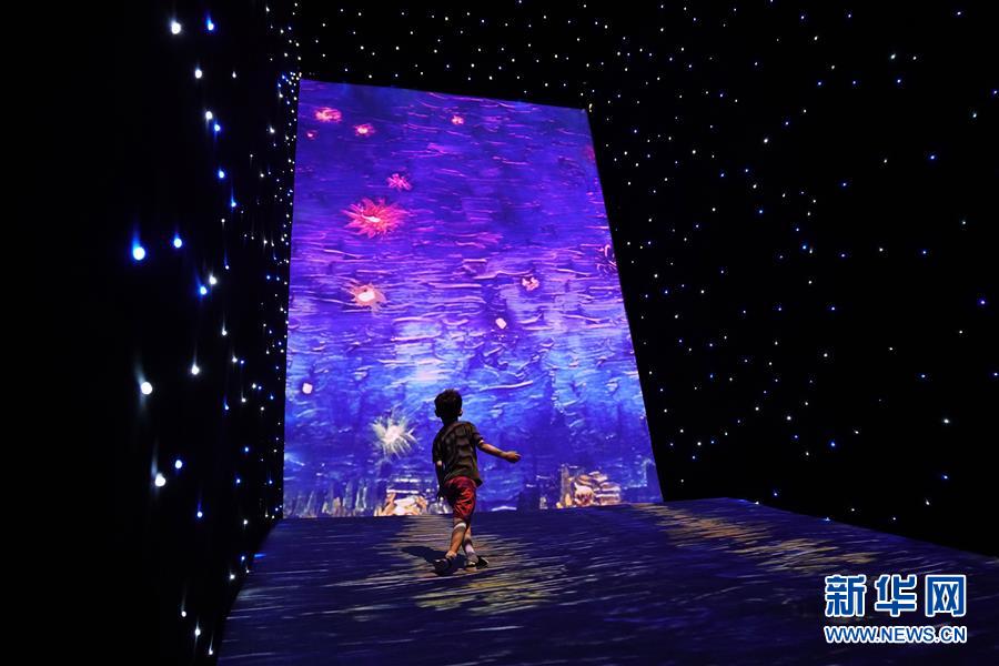 22日、ゴッホの描いた星空を再現した展示室で没入型体験をする子供（撮影・金良快）。