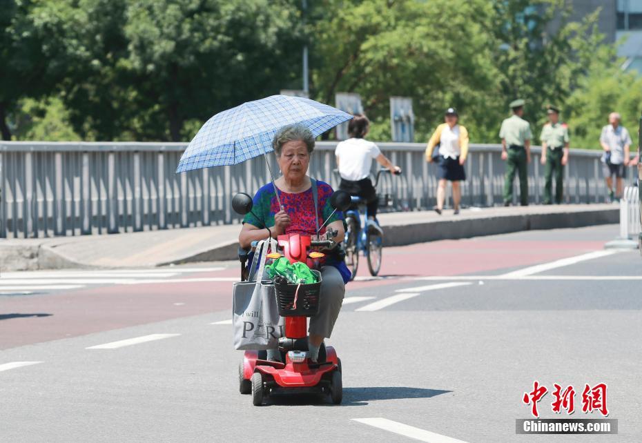 高温が続く猛暑の北京　様々な日焼け対策で外出する市民