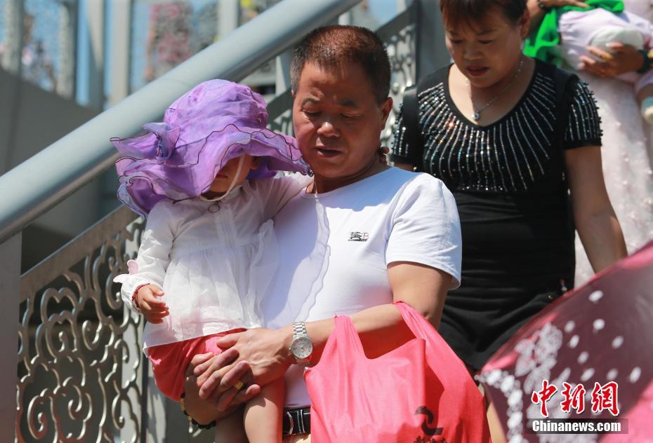 高温が続く猛暑の北京　様々な日焼け対策で外出する市民