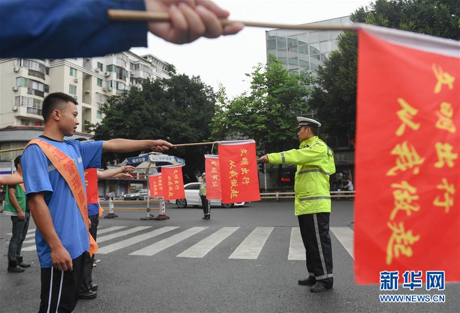7月11日、福建省福州市で配達員に交通整理の誘導サインの手本を示す警察官（撮影・宋為偉）。
