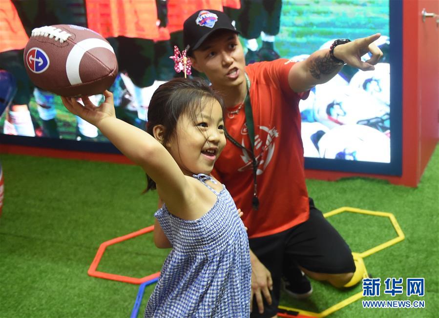 北京玩具博でアメリカンフットボールのゲームを体験する子供（7月11日撮影・羅暁光）。