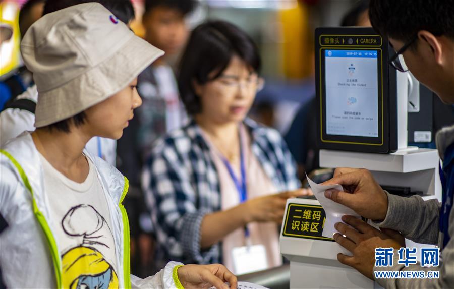昆明駅でeチケットで改札を通る乗客（7月30日撮影・江文耀）。