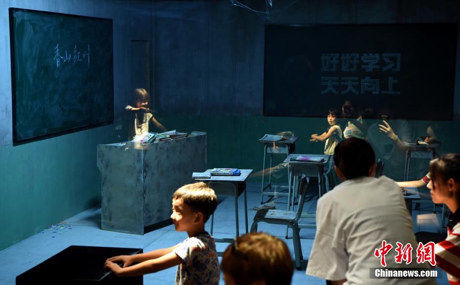 北京で、アルゼンチン出身アーティストのレアンドロ・エルリッヒさんの作品「根こそぎ引っ張られて」を「体験」する人々（8月1日撮影・侯宇）。