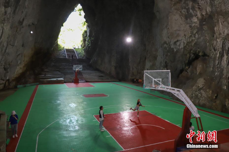 8月12日、鐘乳洞内のバスケットボールコートでプレーする地元の人々 （撮影・瞿宏倫）。