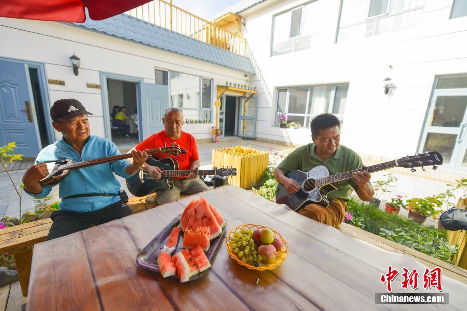 9月27日、新疆ウイグル自治区ウルムチ市の南郊外にある平西梁村で、観光客のために楽器を演奏する民泊施設のスタッフ（撮影・劉新）。