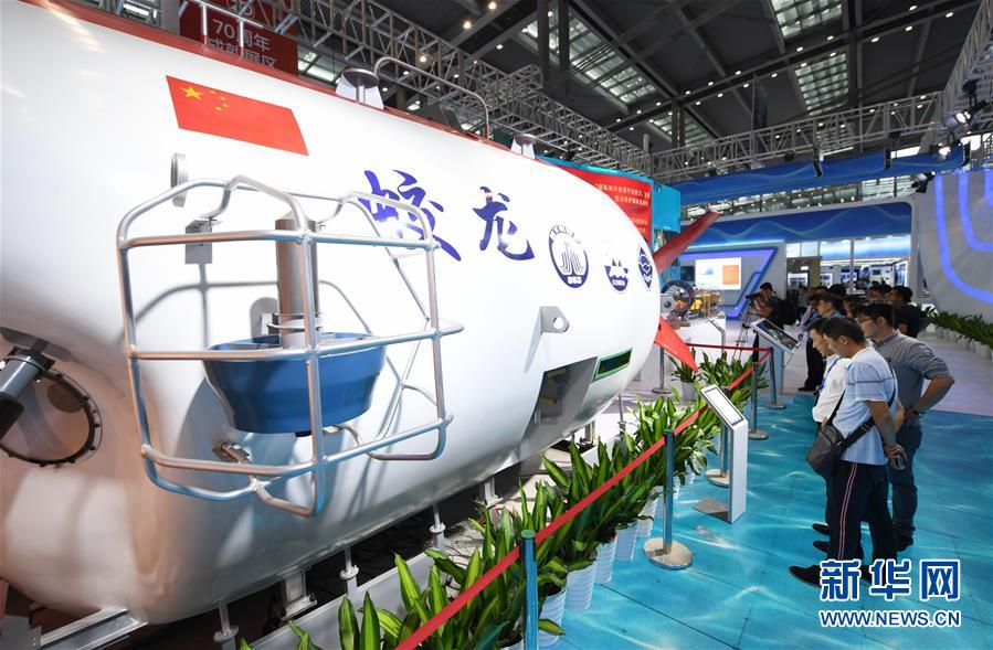 15日、有人潜水艇「蛟竜号」の模型を見学する会議参加者。