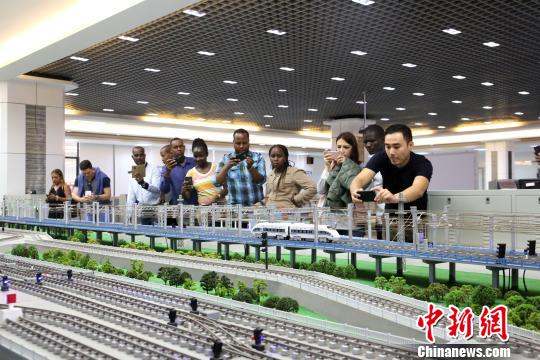 総合運輸実践研修室で建築模型の写真を撮る研修参加者（撮影・朱柳融）。