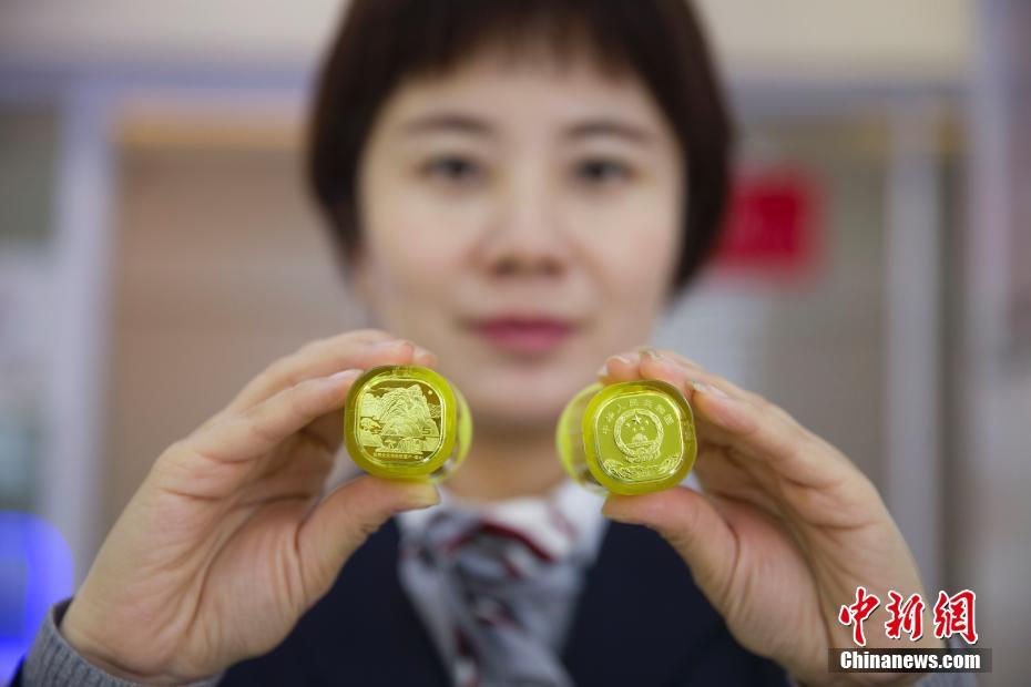 11月28日、山西省太原市で、記念硬貨を見せる銀行員（撮影・張雲）。
