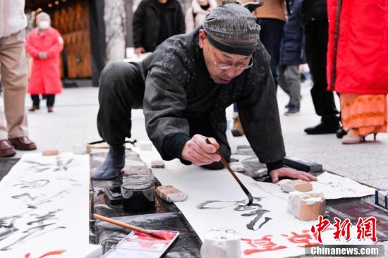 日本人書家、東京の街頭で武漢の幸福祈り揮毫