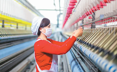 2月14日、海安市曲塘鎮双弘紡織有限公司の生産工場内の自動生産ライン上で作業する女性従業員。撮影：■慧勇（■は曜のつくり、人民視覚）