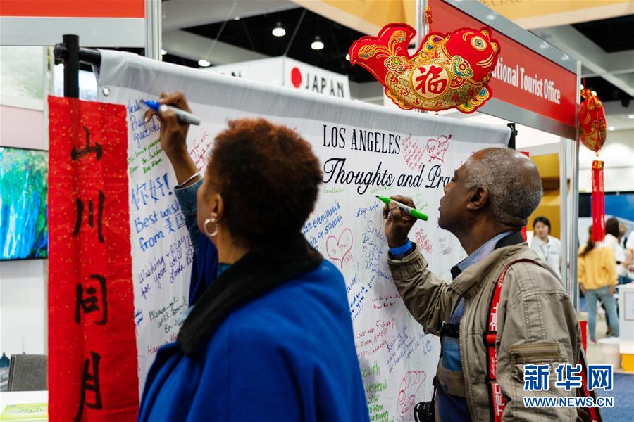 ロサンゼルストラベル・アドベンチャーショーの中国エリアに設けられた伝言板に応援メッセージを書く来場者（2月15日撮影・銭衛忠）。