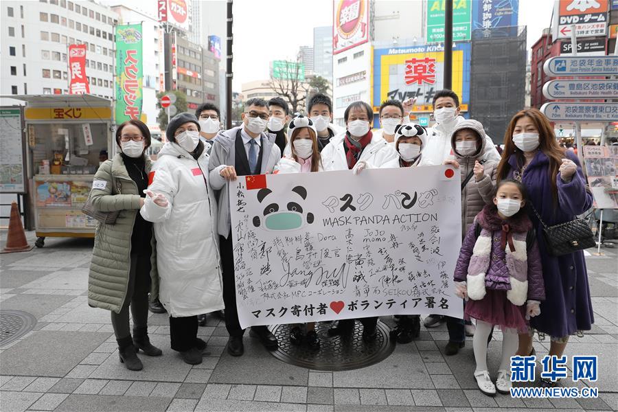 2月29日、日本の東京・池袋駅前で道行く人々にマスクを配った後記念撮影し、中国と日本の感染拡大防止にエールを送る「マスクパンダアクション」のボランティアたち（撮影・杜瀟逸）。