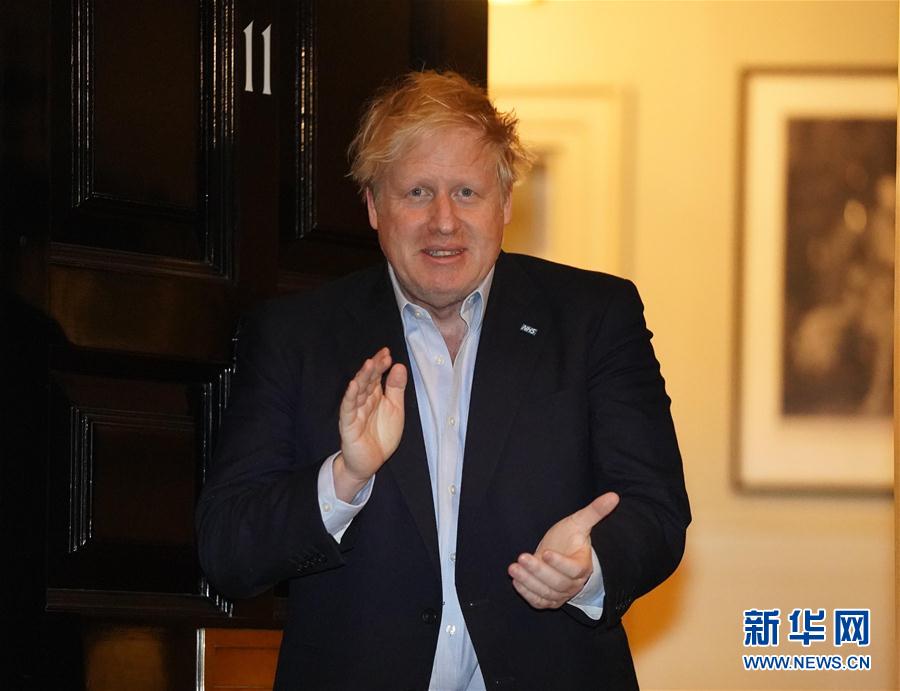4月2日夜、ロンドン・ダウニング街10番地（首相官邸）入り口でNHS（英国国民保健サービス）の医療スタッフに拍手を送るジョンソン英首相（資料提供・英首相官邸）。