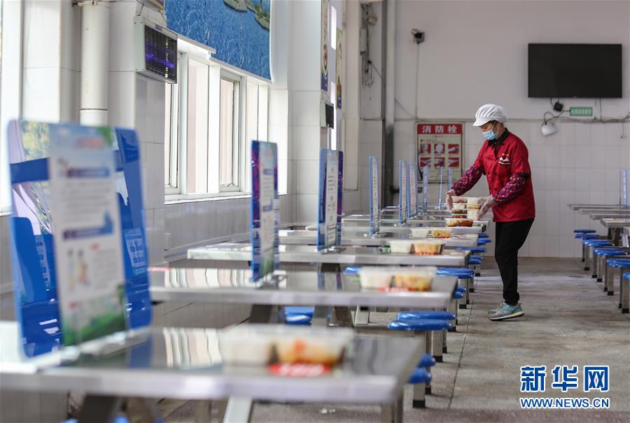4月7日、湖南省永州市零陵区柳子中高一貫校の学生食堂で、距離を取って食事ができるよう生徒の弁当を配膳する職員（撮影・潘愛民）。