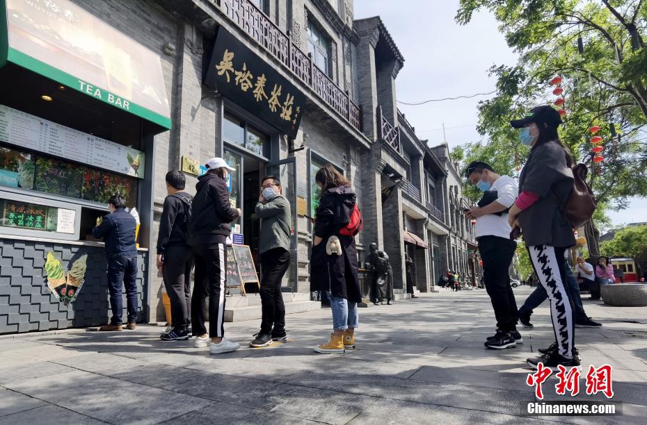 「呉裕泰茶荘」の店舗前で、オリジナル氷飲料や抹茶味アイスクリームを買うために「ソーシャルディスタンス」を保ち列に並ぶ観光客（撮影・張宇）。
