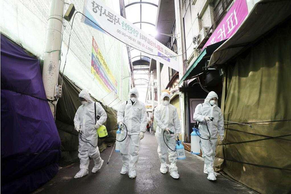 2月、韓国・大邱の商店街で消毒をする作業員。（写真提供はAP通信）