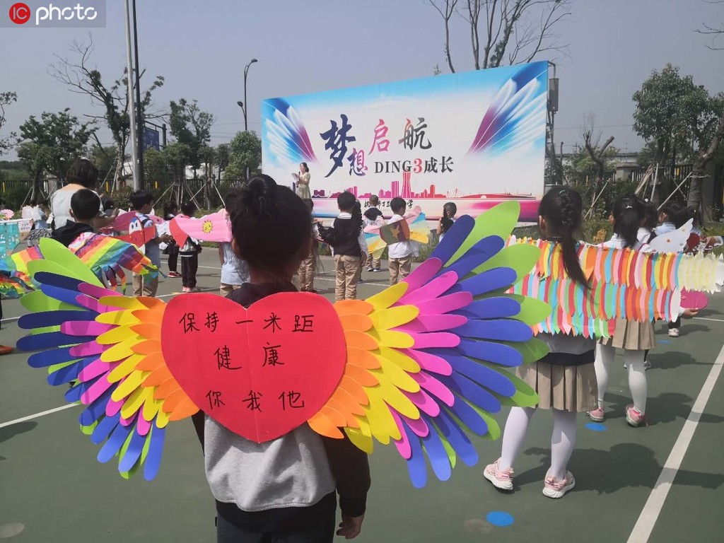 「1メートル幅の翼」を背に登校する可愛い小学生たち　浙江省杭州市