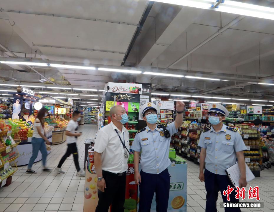 スーパーの店内に設置された消防安全設備が正常に作動するかどうかをチェックする消防管理監督担当者（撮影・王方）。