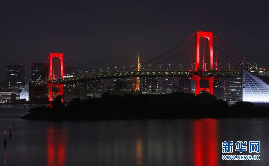 「東京アラート」発動にともない、ライトアップの色が虹色から赤色に変わったレインボーブリッジ（写真提供・新華社、共同通信社）。