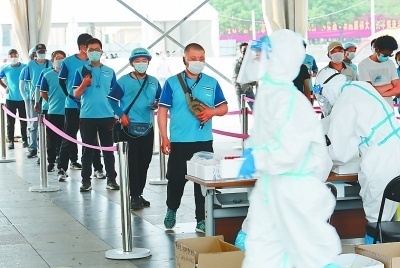 6月20日、西城区北展広場で、PCR検査の検体を採取するために列に並ぶ宅配便、デリバリー業界の従事者。