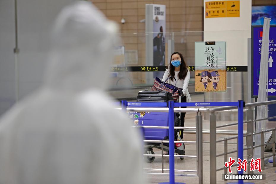 カートを押しながら上海浦東国際空港の到着ロビーに姿を現した米国からの旅客（撮影・殷立勤）。