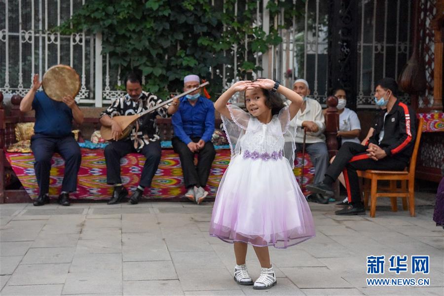 7月4日、ウルムチ・大バザール景勝地で、音楽に合わせて踊りだす子供（撮影・丁磊）。