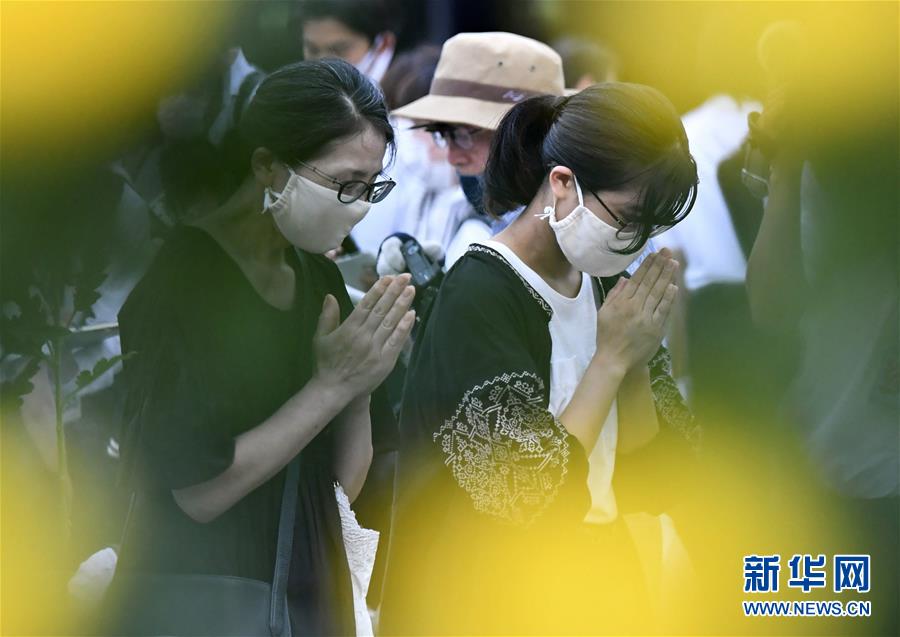 8月6日、広島で行われた平和記念式典開始前に、両手を合わせ平和の祈りをささげる人々（新華社/共同通信社）。