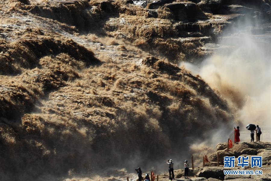 8月10日、山西省吉県の黄河壺口瀑布景勝地で、洪水ピーク後の壮大な滝を鑑賞する観光客（撮影・呂桂明）。