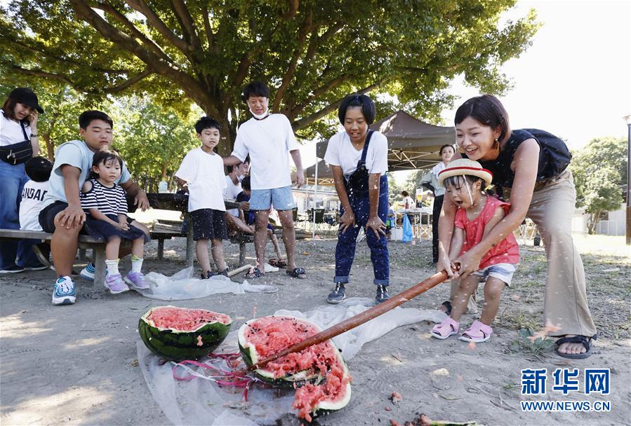 8月11日、東京・葛西臨海公園で、スイカ割りを楽しむ子供と保護者（写真提供・新華社、共同通信社）。