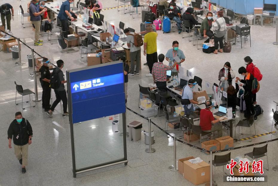 8月17日深夜、香港国際空港の入境手続き前エリアで検疫手続きを行う旅客ら（撮影・張■、■は火へんに韋）。  