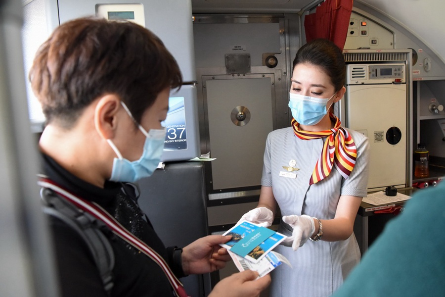 9月15日、旅客に「カナス号」初フライト記念ポストカードを配る客室乗務員（撮影・丁磊）。