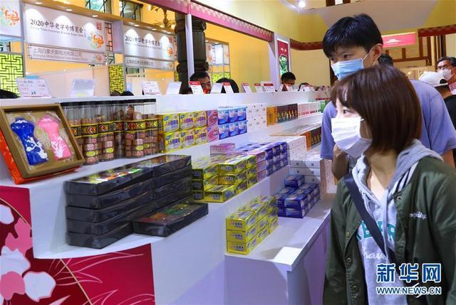 10月10日、上海制皂有限公司が出展した製品を見学する2人の若者（撮影・方喆）。