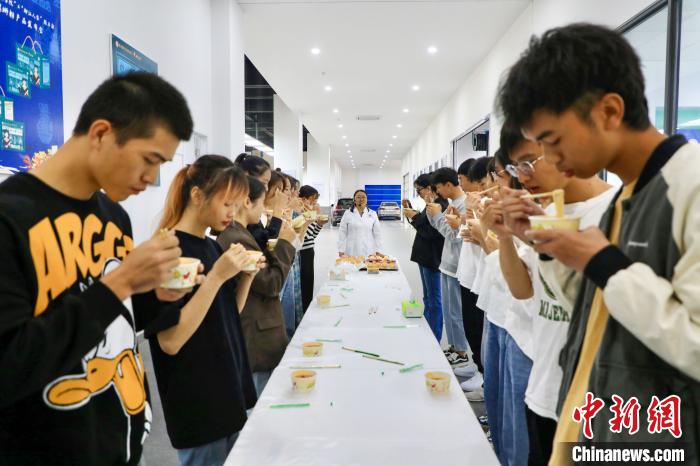 タニシ麺副専攻クラスでタニシ麺を一斉に試食する学生（撮影・楊琳）。