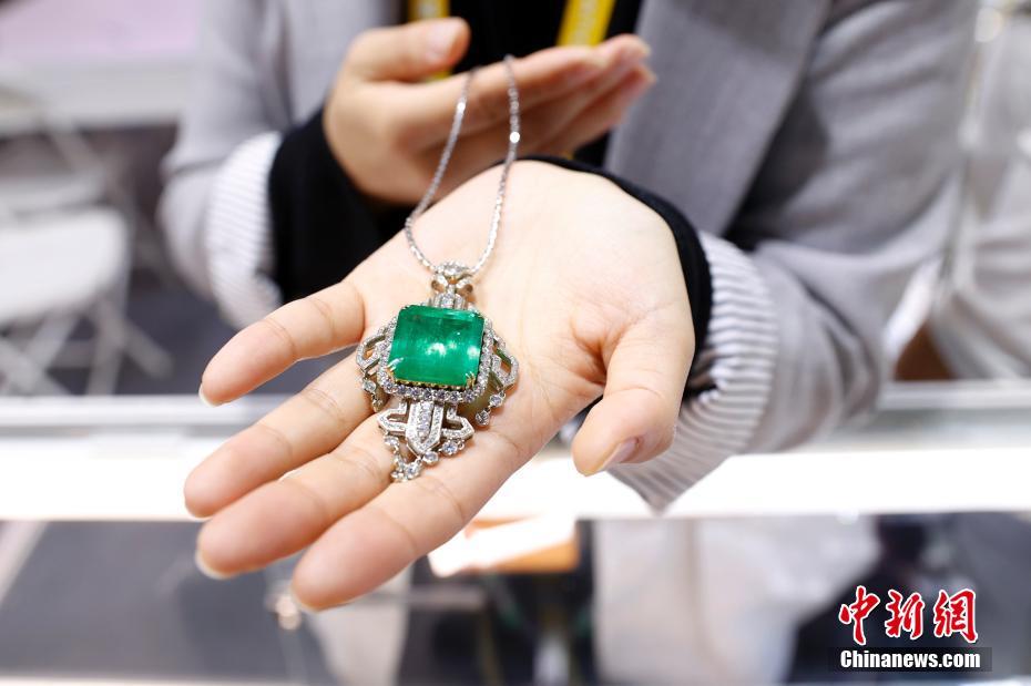 消費財展示エリアで、コロンビア産のエメラルドジュエリーを展示する香港紫合門珠宝有限公司のスタッフ（撮影・韓海丹）。