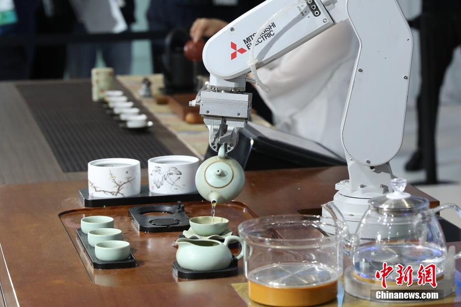 茶芸師とロボットが並んで中国茶の茶芸を披露（撮影・張亨偉）。
