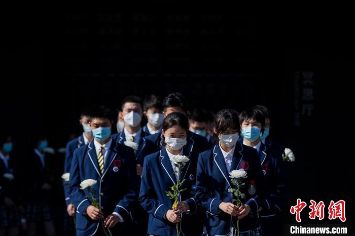 中国侵略日本軍南京大虐殺遭難同胞紀念館を訪れ、犠牲者に菊の花を手向ける南京大学附属中学・高校の教員と学生（撮影・泱波）。