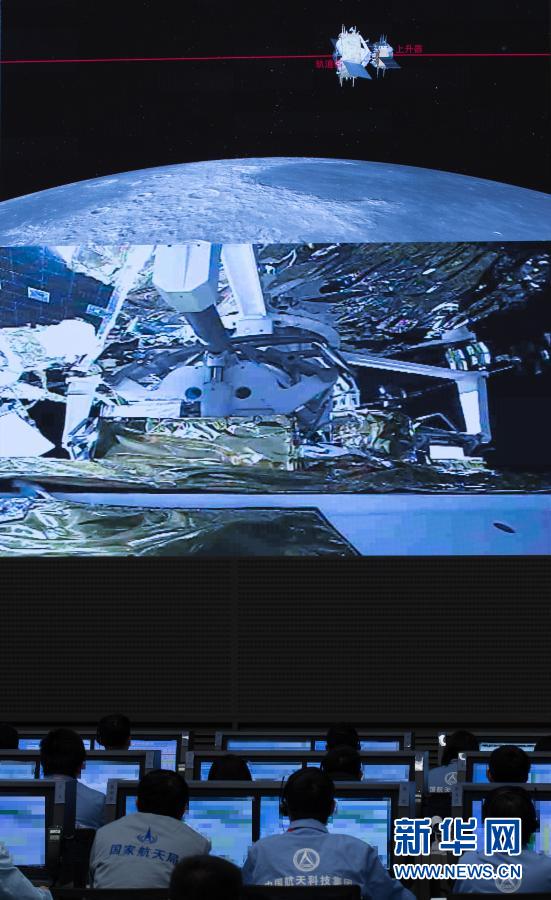 北京宇宙飛行制御センター指揮ホールで6日に撮影された、嫦娥5号の上昇モジュールが軌道モジュールと帰還モジュールの結合体とランデブー・ドッキングする様子